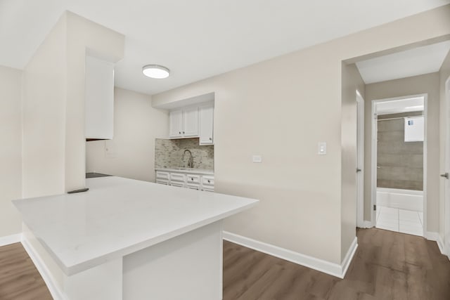 6432 N Ridge Ave Unit 3I, Chicago, IL 60626 - kitchen with dark wood-style floors, light countertops, a peninsula, white cabinets, and tasteful backsplash