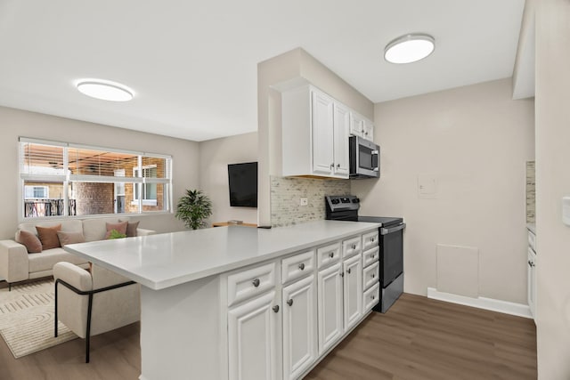 6432 N Ridge Ave Unit 3I, Chicago, IL 60626 - kitchen with stainless steel appliances, light wood-type flooring, a peninsula, and decorative backsplash
