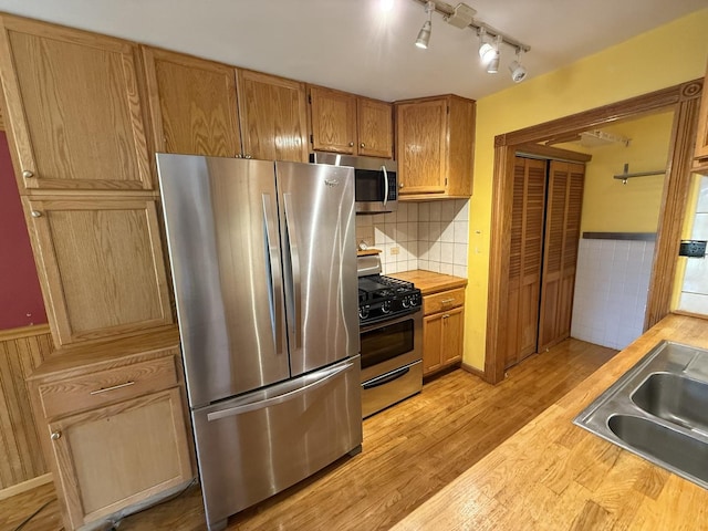 1690 Ashburn Ct Unit A, Wheaton, IL 60189 - kitchen with appliances with stainless steel finishes, light wood-style floors, a wainscoted wall, butcher block counters, and rail lighting