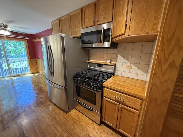 1690 Ashburn Ct Unit A, Wheaton, IL 60189 - kitchen with appliances with stainless steel finishes, ceiling fan, light wood-style floors, brown cabinetry, and a wainscoted wall