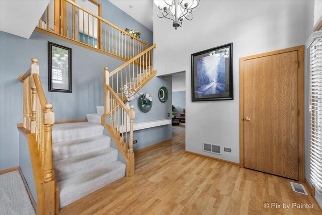 2370 Nantucket Ln, Elgin, IL 60123 - foyer entrance with stairway, wood finished floors, a chandelier, and a towering ceiling