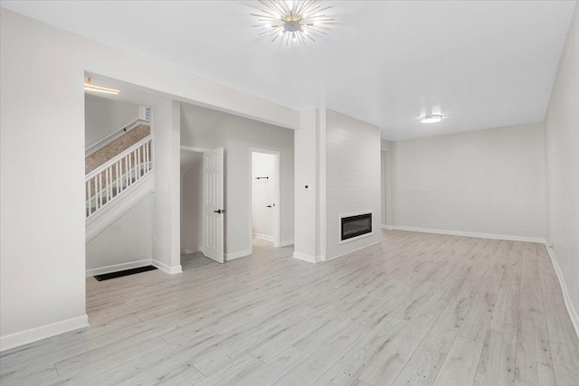 7111 S Michigan Ave, Chicago, IL 60619 - unfurnished living room with wood finished floors, a fireplace, and stairway