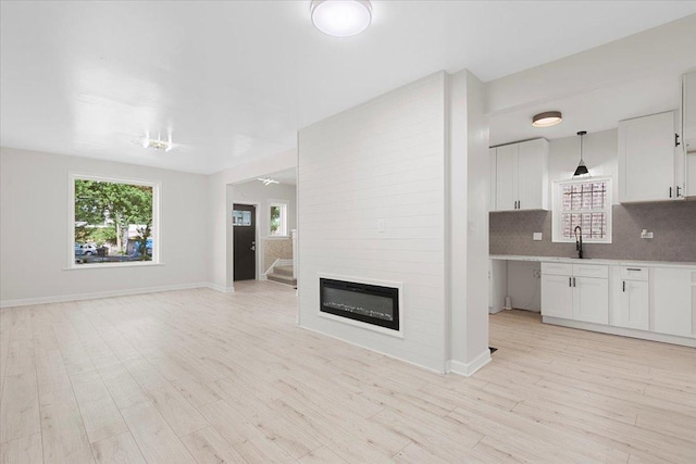 7111 S Michigan Ave, Chicago, IL 60619 - unfurnished living room with light wood-style flooring and a fireplace