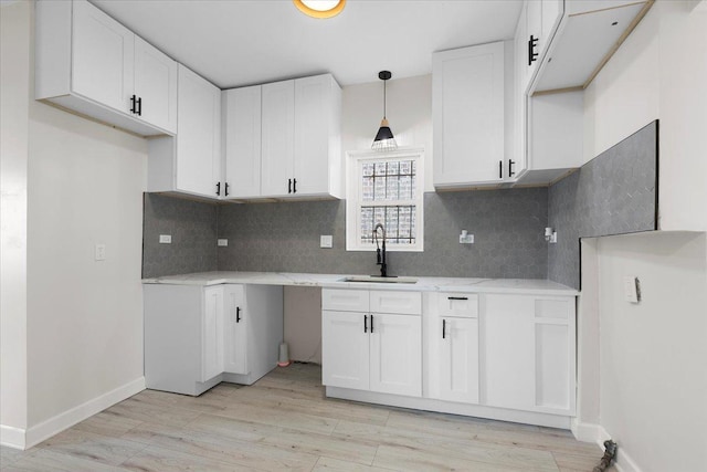 7111 S Michigan Ave, Chicago, IL 60619 - kitchen featuring decorative backsplash, light wood-type flooring, and white cabinets