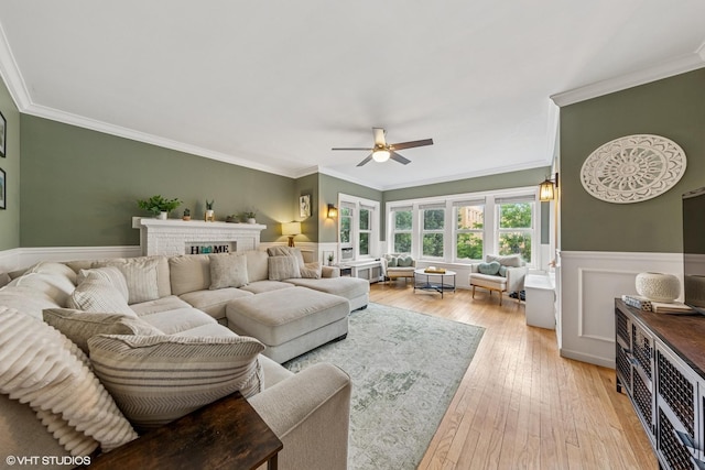 427 S Taylor Ave Unit 2N, Oak Park, IL 60304 - living room featuring ornamental molding, a ceiling fan, light wood-style flooring, a wainscoted wall, and a fireplace