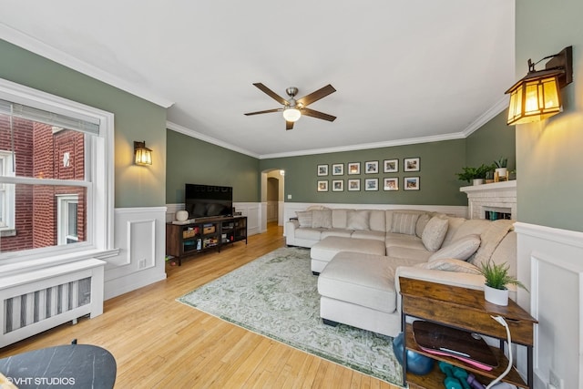 427 S Taylor Ave Unit 2N, Oak Park, IL 60304 - living room with radiator, a ceiling fan, crown molding, arched walkways, and wood finished floors