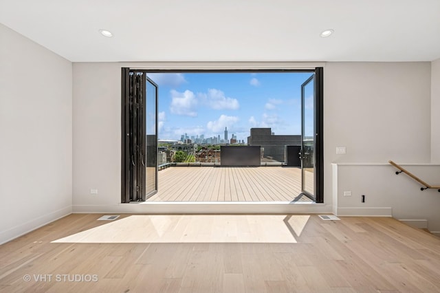 222 S Oakley Blvd Unit 3, Chicago, IL 60612 - empty room with wood finished floors, a view of skyline, recessed lighting, and expansive windows