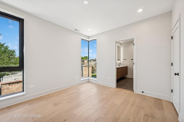 222 S Oakley Blvd Unit 3, Chicago, IL 60612 - unfurnished bedroom with multiple windows, light wood finished floors, recessed lighting, and ensuite bathroom
