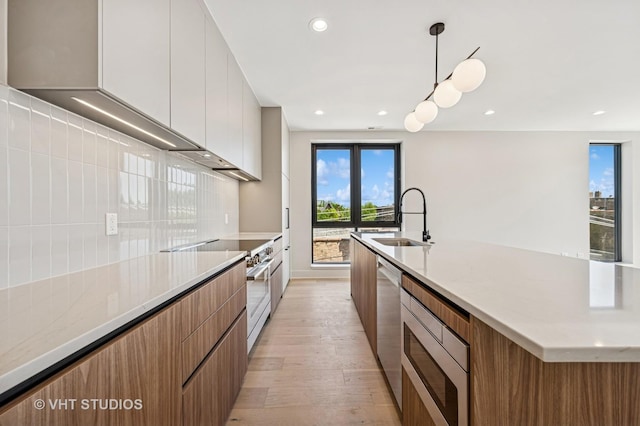 222 S Oakley Blvd Unit 3, Chicago, IL 60612 - kitchen with modern cabinets, stainless steel appliances, light wood-type flooring, brown cabinets, and a large island with sink