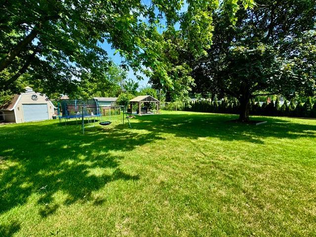 1211 Highland Dr, Prospect Heights, IL 60070 - view of yard with a trampoline, a gazebo, and a storage shed