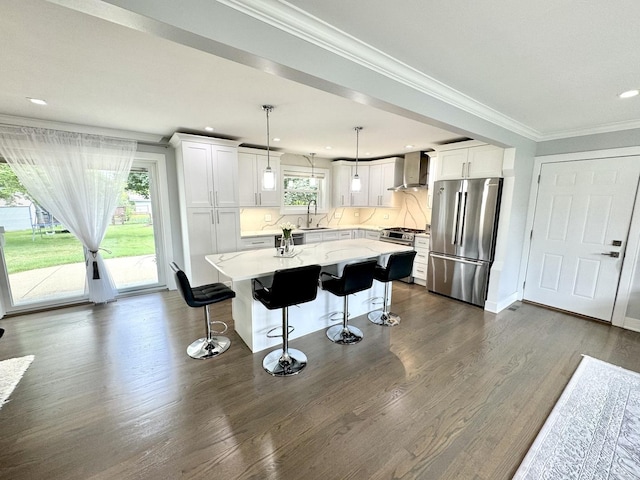 1211 Highland Dr, Prospect Heights, IL 60070 - kitchen featuring stainless steel appliances, wall chimney range hood, white cabinets, a center island, and a kitchen bar