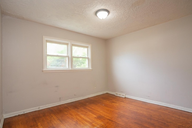 15533 Vincennes Rd, Phoenix, IL 60426 - spare room featuring wood finished floors and a textured ceiling