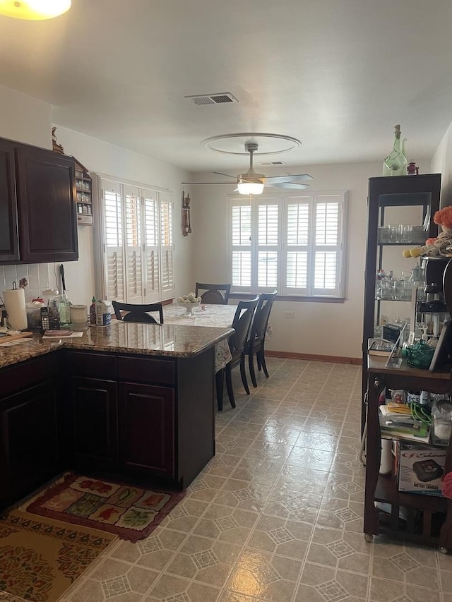 2940 N Nagle Ave, Chicago, IL 60634 - kitchen featuring plenty of natural light, a peninsula, a ceiling fan, and dark stone countertops
