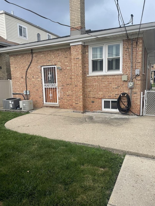 2940 N Nagle Ave, Chicago, IL 60634 - rear view of house featuring a patio area, brick siding, and a chimney