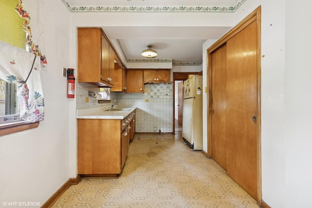 12358 S Lowe Ave, Chicago, IL 60628 - kitchen featuring freestanding refrigerator, brown cabinetry, light countertops, tasteful backsplash, and light floors