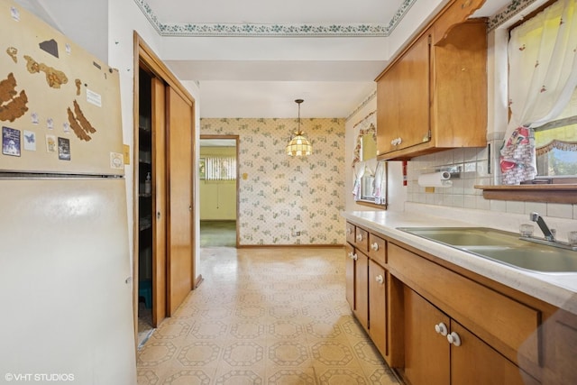 12358 S Lowe Ave, Chicago, IL 60628 - kitchen featuring freestanding refrigerator, brown cabinets, light floors, light countertops, and wallpapered walls