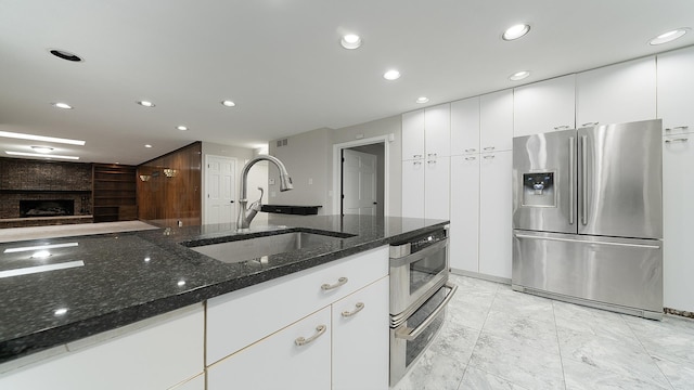 5809 Inverness Dr, Rockford, IL 61107 - kitchen with stainless steel fridge with ice dispenser, dark stone countertops, light marble finish flooring, recessed lighting, and white cabinetry