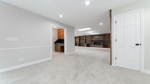 5809 Inverness Dr, Rockford, IL 61107 - unfurnished living room featuring light colored carpet, recessed lighting, a fireplace, and built in shelves