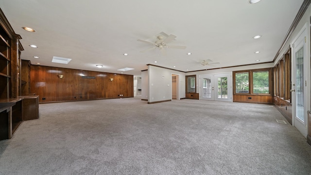 5809 Inverness Dr, Rockford, IL 61107 - unfurnished living room with french doors, recessed lighting, light carpet, a ceiling fan, and wood walls