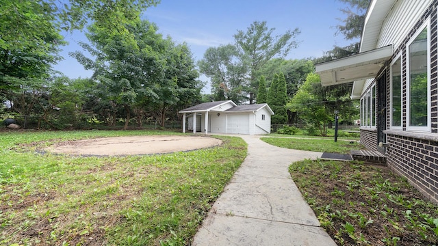 5809 Inverness Dr, Rockford, IL 61107 - view of yard featuring concrete driveway, a detached garage, and an outdoor structure