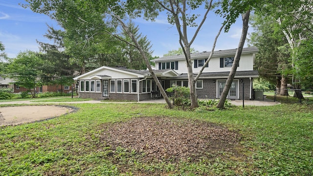 5809 Inverness Dr, Rockford, IL 61107 - rear view of house featuring a sunroom, brick siding, and a patio area
