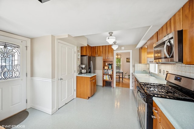 1300 Highridge Pkwy, Westchester, IL 60154 - kitchen with appliances with stainless steel finishes, brown cabinets, light countertops, wainscoting, and light floors