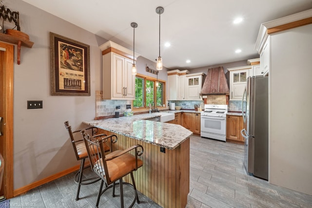 1448 Chestnut Xing, Lemont, IL 60439 - kitchen featuring white range, freestanding refrigerator, custom exhaust hood, a peninsula, and decorative backsplash