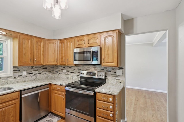 32 Woodridge Ln, Streamwood, IL 60107 - kitchen featuring appliances with stainless steel finishes, light wood finished floors, tasteful backsplash, and light stone counters