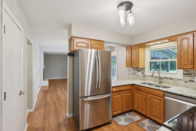 32 Woodridge Ln, Streamwood, IL 60107 - kitchen featuring appliances with stainless steel finishes, light wood finished floors, light stone counters, and decorative backsplash