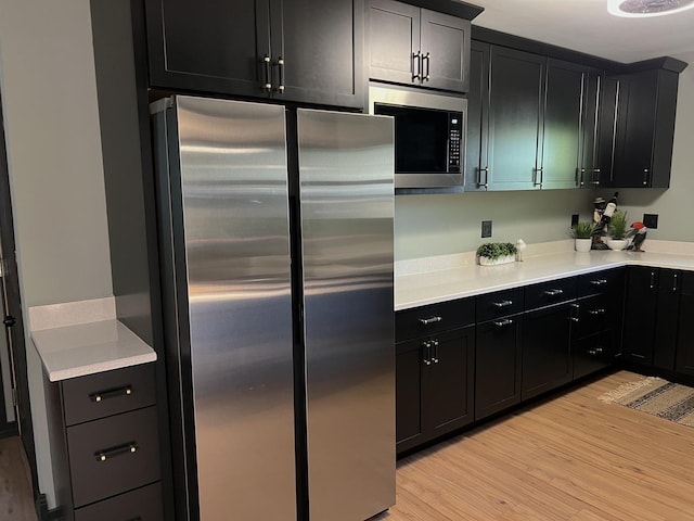 5 Knollcrest Ct, Normal, IL 61761 - kitchen featuring appliances with stainless steel finishes, light wood-style flooring, dark cabinets, and light countertops