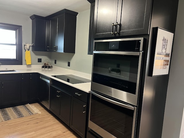 5 Knollcrest Ct, Normal, IL 61761 - kitchen with appliances with stainless steel finishes, light wood-style flooring, dark cabinetry, and light countertops