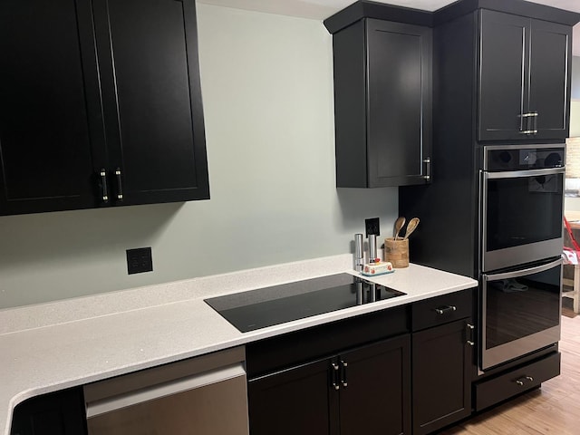 5 Knollcrest Ct, Normal, IL 61761 - kitchen featuring appliances with stainless steel finishes, dark cabinetry, light countertops, and light wood-style floors
