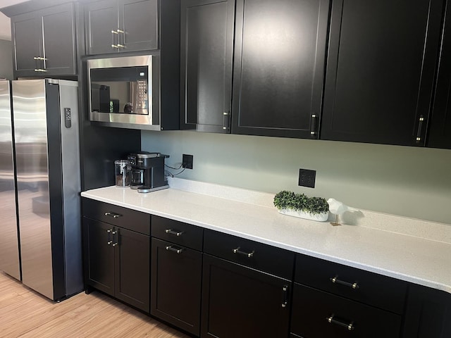 5 Knollcrest Ct, Normal, IL 61761 - kitchen with stainless steel appliances, dark cabinetry, and light wood-style floors
