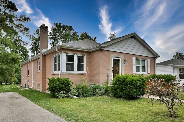 1747 Linneman St, Glenview, IL 60025 - view of front of home featuring a chimney, brick siding, and a front yard