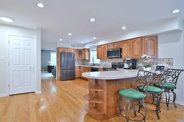 1747 Linneman St, Glenview, IL 60025 - kitchen with electric stove, freestanding refrigerator, a peninsula, brown cabinetry, and light countertops