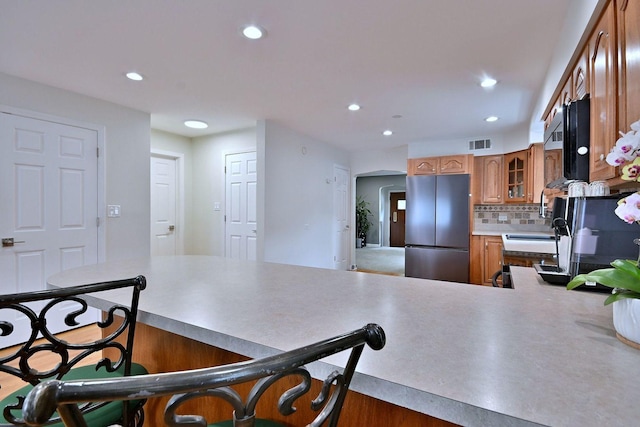 1747 Linneman St, Glenview, IL 60025 - kitchen with freestanding refrigerator, a peninsula, brown cabinets, glass insert cabinets, and recessed lighting