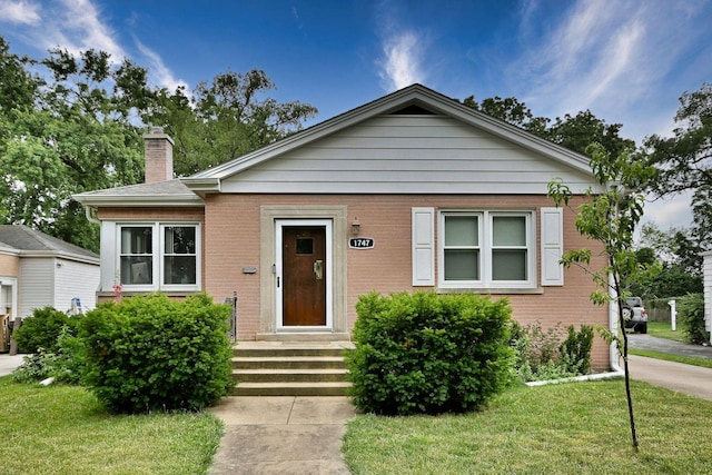 1747 Linneman St, Glenview, IL 60025 - bungalow featuring a chimney, a front yard, and brick siding