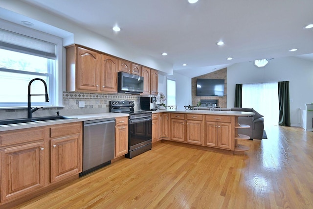 1747 Linneman St, Glenview, IL 60025 - kitchen with stainless steel appliances, a peninsula, tasteful backsplash, light wood finished floors, and vaulted ceiling