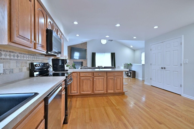 1747 Linneman St, Glenview, IL 60025 - kitchen featuring stainless steel appliances, a peninsula, lofted ceiling, light wood-style flooring, and light countertops
