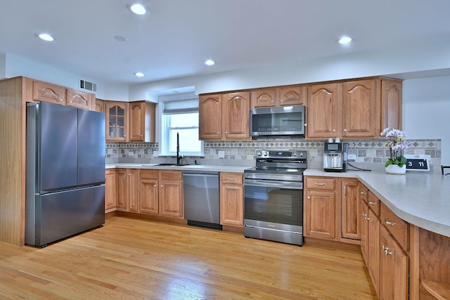 1747 Linneman St, Glenview, IL 60025 - kitchen with appliances with stainless steel finishes, tasteful backsplash, brown cabinets, light countertops, and light wood-type flooring