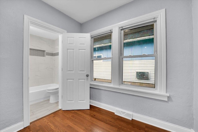 305 S Lewis Ave, Waukegan, IL 60085 - full bath featuring wood finished floors, a textured wall, and shower / washtub combination