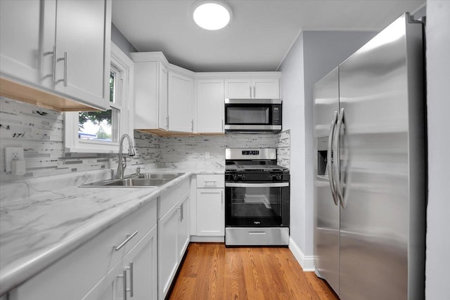 305 S Lewis Ave, Waukegan, IL 60085 - kitchen with appliances with stainless steel finishes, white cabinetry, light wood-style flooring, and tasteful backsplash