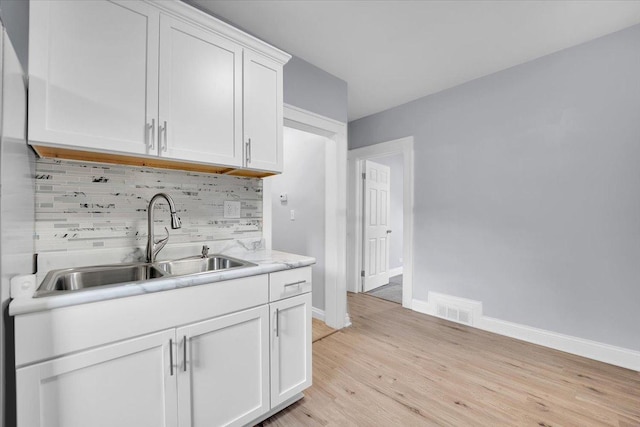 305 S Lewis Ave, Waukegan, IL 60085 - kitchen featuring light countertops, white cabinetry, backsplash, and light wood-type flooring