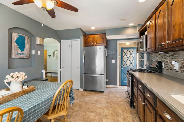 49 Burton Ave, Cary, IL 60013 - kitchen featuring appliances with stainless steel finishes, tasteful backsplash, a ceiling fan, arched walkways, and lofted ceiling