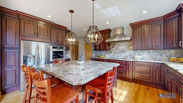 19113 Lauren Ln, Marengo, IL 60152 - kitchen with wall chimney range hood, appliances with stainless steel finishes, a kitchen island, a chandelier, and backsplash