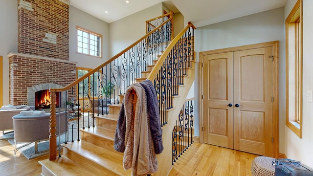 19113 Lauren Ln, Marengo, IL 60152 - stairs with wood finished floors, a brick fireplace, recessed lighting, and a towering ceiling