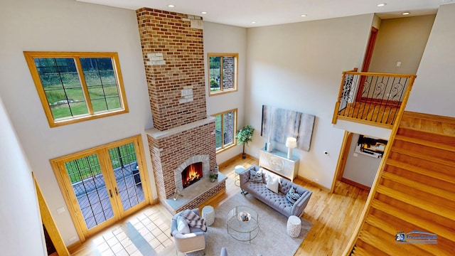19113 Lauren Ln, Marengo, IL 60152 - living room featuring plenty of natural light, a fireplace, french doors, a towering ceiling, and recessed lighting