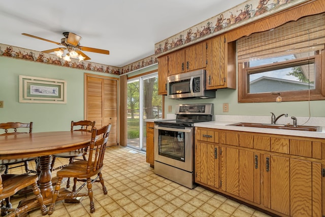 955 E 5th St, Coal City, IL 60416 - kitchen with stainless steel appliances, light countertops, light flooring, ceiling fan, and brown cabinets
