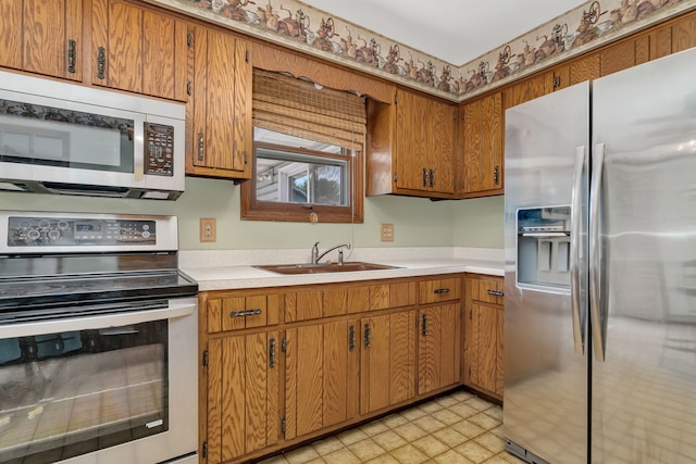 955 E 5th St, Coal City, IL 60416 - kitchen featuring appliances with stainless steel finishes, light countertops, brown cabinets, and light flooring