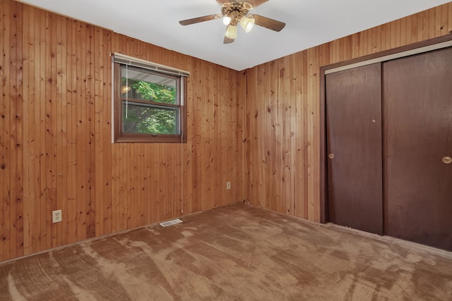955 E 5th St, Coal City, IL 60416 - unfurnished bedroom featuring carpet flooring, a closet, wood walls, and ceiling fan